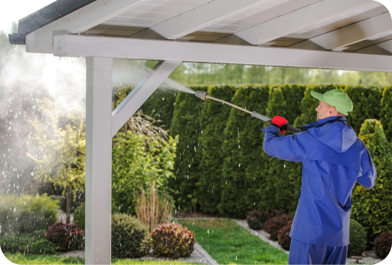 Pressure washing roof beams and patio cover outdoors.