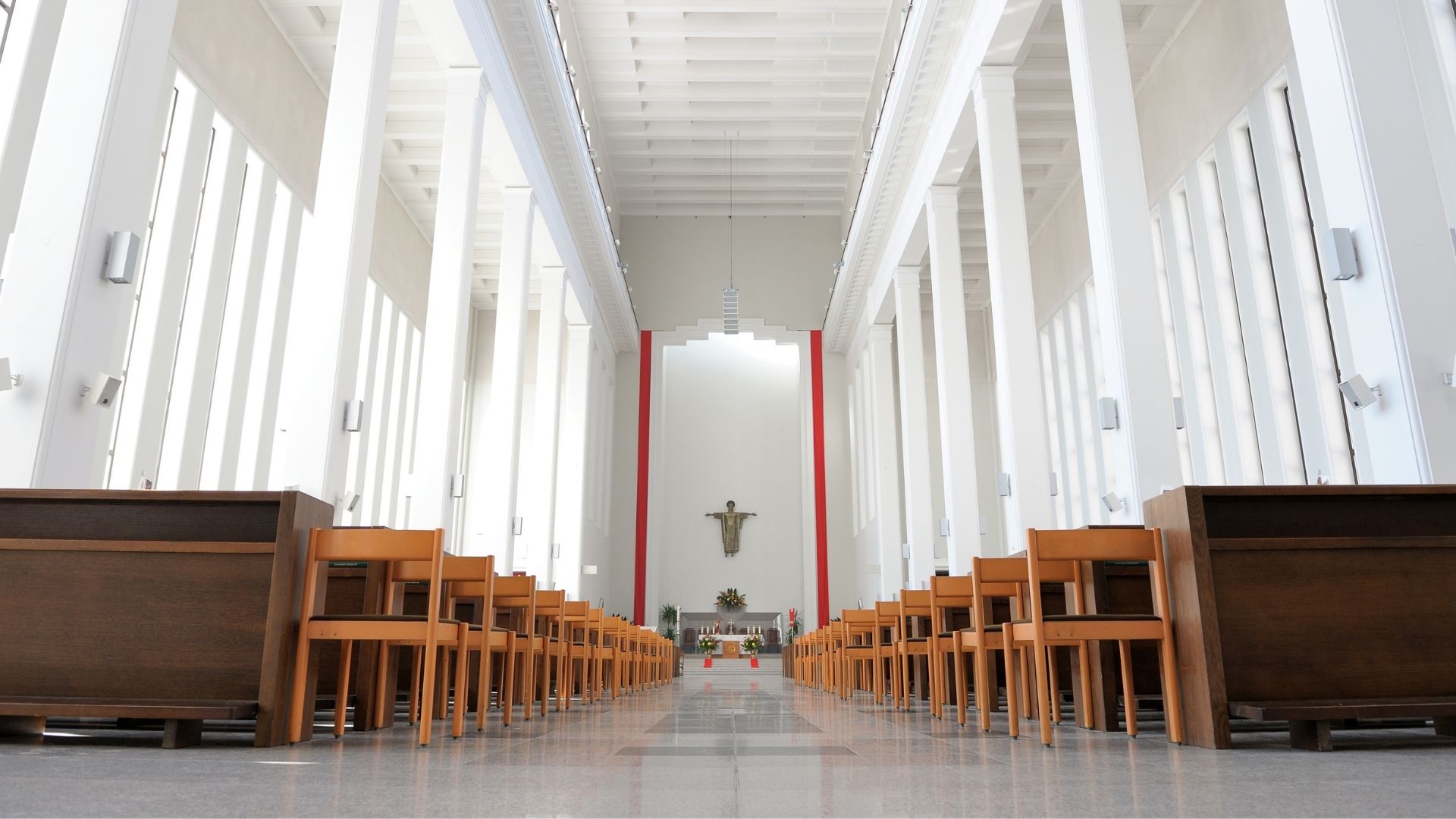 Clean and well-maintained church interior with seating and aisle prepared for use by Pharo Cleaning.